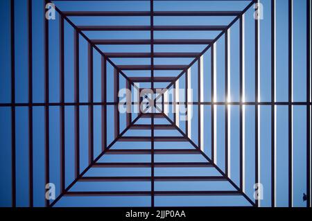 A low-angle shot of a glass ceiling against a blue sky Stock Photo