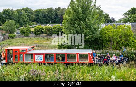 Ratho, Scotland, United Kingdom, 27th July 2022. UK Weather: sunny evening on the Union Canal. A group enjoy a cruise along the canal in a narrow boat Stock Photo