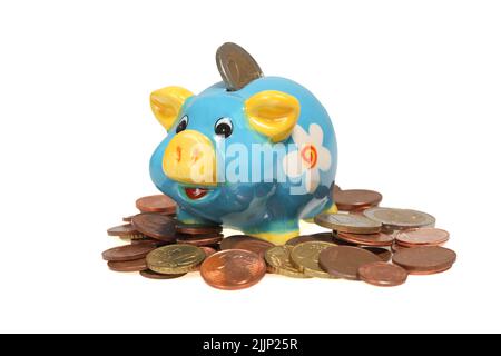 A blue piggy bank with a euro coin, on a pile of coins, isolated on a white background Stock Photo