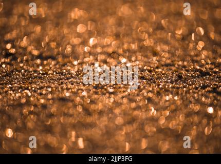 A closeup shot of sand at sunset on the beach in Faro, Portugal Stock Photo