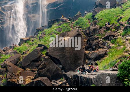 Hikers relaxing by Vernal Falls on the Mist Trail in Yosemite National Park, California Stock Photo
