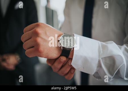 A closeup shot of a Man wearing a luxury watch with a white formal outfit concept of business in Sarajevo, Bosnia and Herzegovina Stock Photo