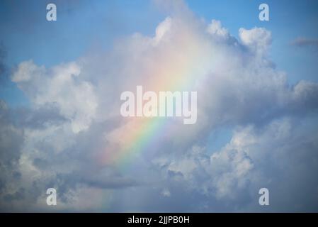 A beautiful low angle view of a light rainbow on the clouds in the sky Stock Photo