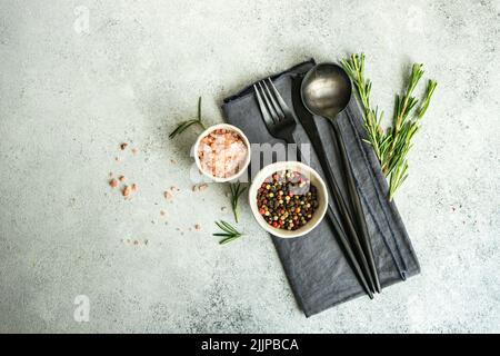 Overhead view of a place setting with pink Himalayan salt, mixed peppercorns and rosemary Stock Photo