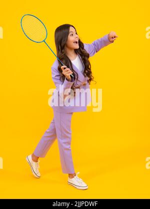 Teen girl badminton player with badminton racket isolated on yellow background. Stock Photo