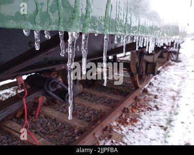 a closeup shot of icicles on the train on the rusty railway Stock Photo