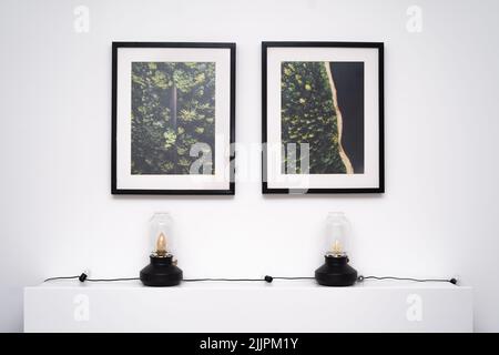 Two black frames of photos hanging on the wall in the room above the bedframe Stock Photo