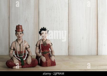 A beautiful shot of Javanese bride statue decorations on wooden background Stock Photo