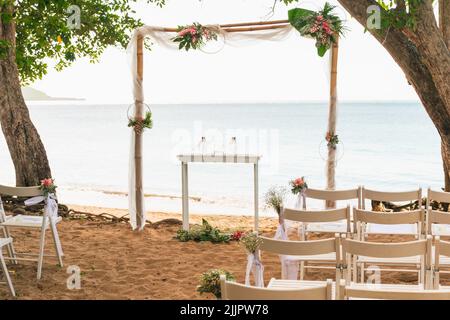 A simple beach wedding set up beside a tree on the seaside Stock Photo