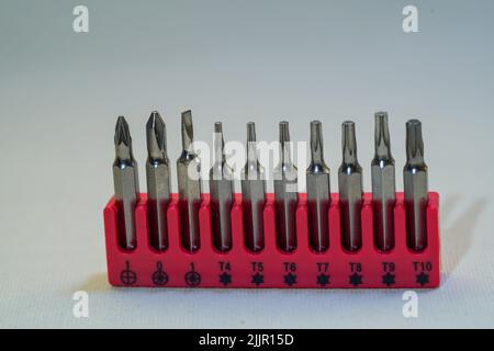 A closeup of a set of screwdriwers with different sizes in their red stand on a plain background Stock Photo
