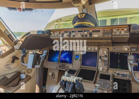 A view of cockpit of a 747-8F aircraft with captain hat on the avionics Stock Photo