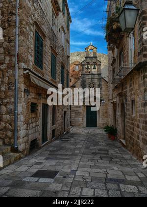 An outdoor view of a narrow empty street between old brick buildings in Dubrovnik, Croatia Stock Photo