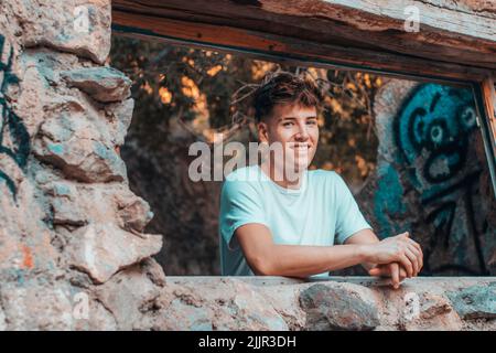 A blonde Spanish man smiling and leaning on the stone Stock Photo