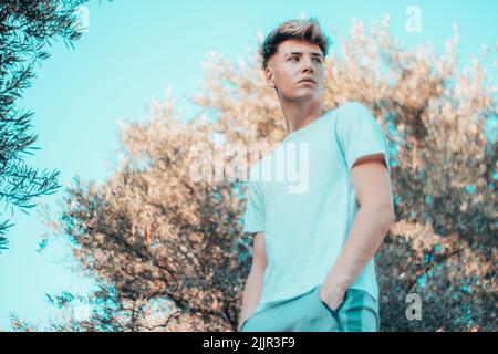 A blonde Spanish man looking away in the park Stock Photo