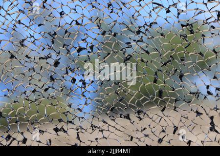 Beautiful black and silver lines of a shattered window create an intricate landscape image. Stock Photo