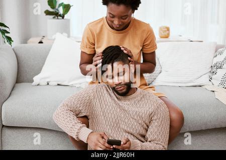 Our connection is all you need. a young couple using a phone at home. Stock Photo