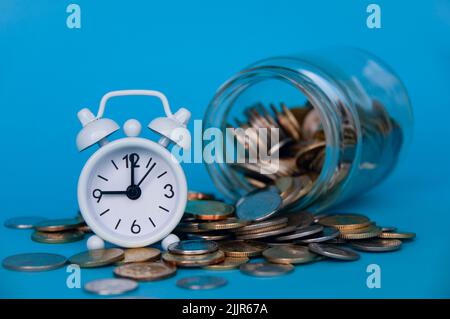 Scattered gold coins and alarm clock with space customizable for text or ideas . Copy space and investment concept Stock Photo