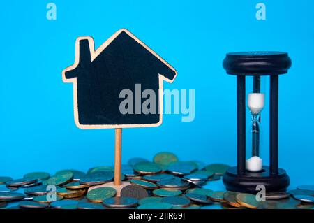 Scattered gold coins and blank model house with space customizable for text or ideas . Copy space and investment concept Stock Photo