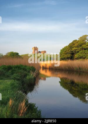 A beautiful view of a stream with the Red Castle of Lunan in the background in the morning Stock Photo