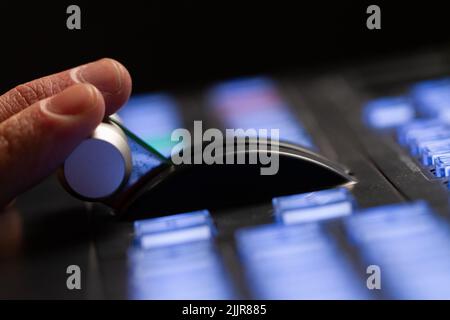 Hand operating video production switcher, in studio station, audio and video production switcher of television broadcast. Stock Photo