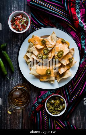 Mexican nachos chips with american cheese, beer and jalapeños in Mexico Latin America Stock Photo