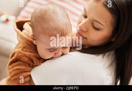 What happened my little one. a young mother consoling her crying baby. Stock Photo