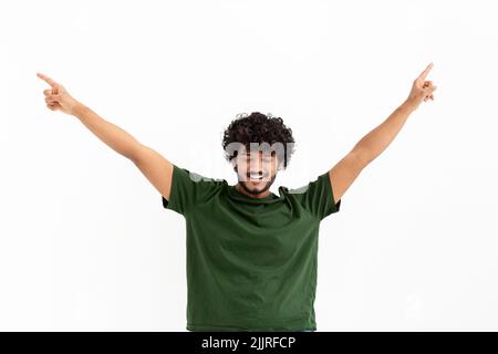 Portrait of happy young Asian man with curly hair celebrating victory raised his hands up on white background Stock Photo