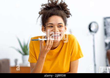 Young African american woman sending voice message through using mobile phone Stock Photo