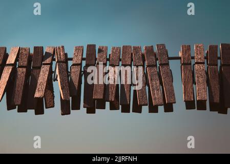 A closeup shot of wooden clothespins on a rope Stock Photo