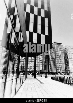 A grayscale vertical shot of modern highrise buildings Stock Photo