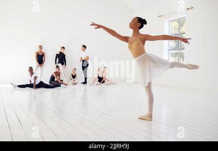 Aim to move the whole being together in harmony. a group of ballet dancers practicing a routine in a dance studio. Stock Photo