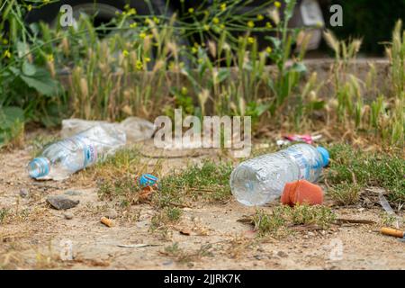A close-up of two empty plastic water bottles on the ground Stock Photo