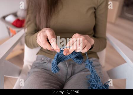 close-up knitting hands. hobby and leisure, crochet scarf. Freelance creative working and living Stock Photo