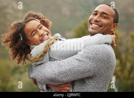 She gets her playful side from me. a handsome young man holding his daughter and bonding with her in the garden. Stock Photo