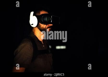 Single man wearing a VR headset in a dark sp Stock Photo