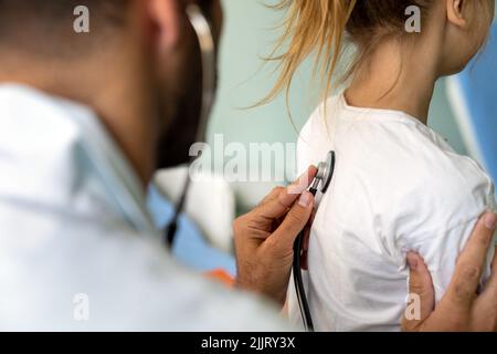 Healthcare medical exam people child concept. Close up of happy girl and doctor with stethoscope Stock Photo