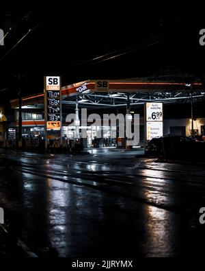 A beautiful shot of SB Tankstelle, a Gas station in Dorsten, Germany at night with wet shiny roads Stock Photo