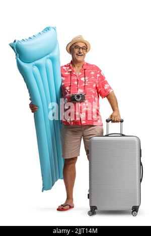 Happy mature male tourist holding a inflatable mattress and a suitcase isolated on a white background Stock Photo