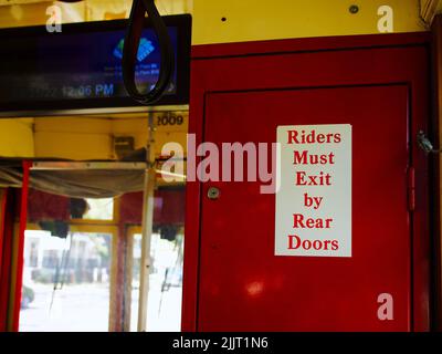 A sign indicates to riders to exit the rear doors of the streetcar in New Orleans, United States Stock Photo