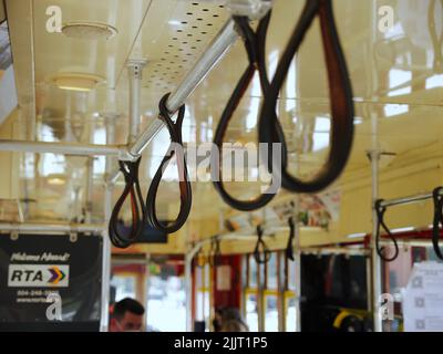 A closeup shot of leather hand grips in the Streetcar during daytime, Canal Street, New Orleans, United States Stock Photo