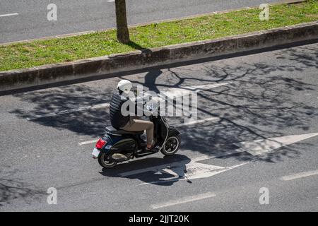 A photo of a motorcyclist with a black Vespa Gts 125 on the streets of Lisbon Stock Photo