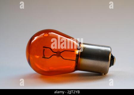 A closeup of orange light bulb on gray background Stock Photo