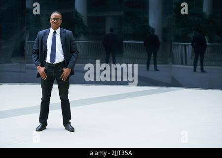 Full-length portrait of confident Africa-American businessman smiling and looking at camera Stock Photo