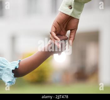 I will always guide and protect you. Closeup shot of an unrecognisable mother and daughter holding hands together outdoors. Stock Photo