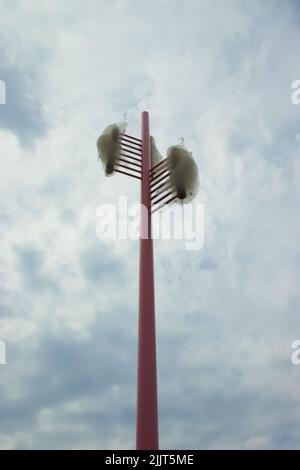 Pink artistic lamppost under blue sky Stock Photo