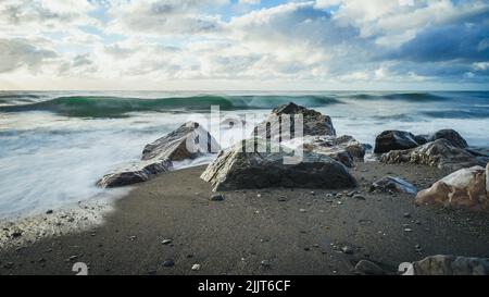 A rocky seashore of a wavy sea Stock Photo