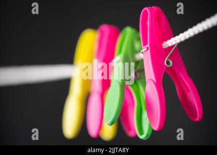 Den Helder, Netherlands. July 2022. Colored plastic clothespins on a clothesline. High quality photo. Close up. Isolated on black. Selective focus. Stock Photo