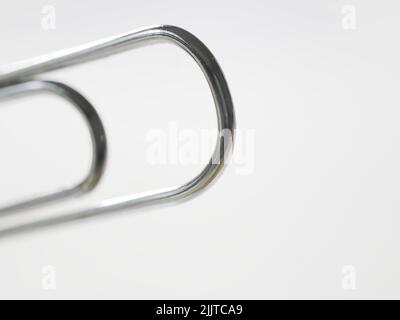 A closeup of a paper clip on a white background Stock Photo