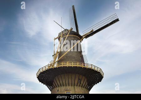 A low angle of a medieval windmill with sails on the sky background Stock Photo