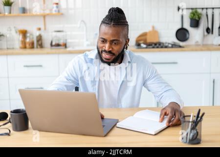 smiling African American confident businessman using laptop computer Remote work concept Stock Photo